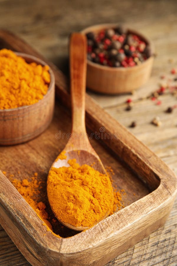 Spoon and bowl with saffron powder on wooden table royalty free stock photo