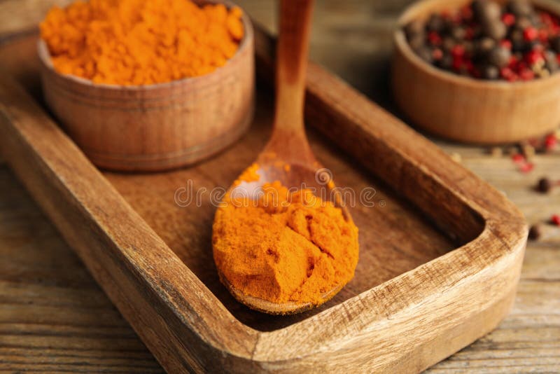 Spoon and bowl with saffron powder on wooden table, closeup stock images