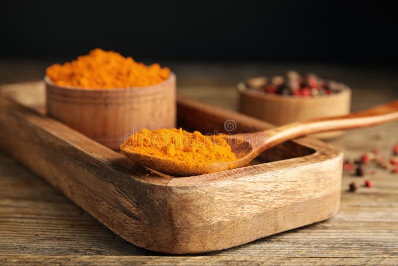 Spoon and bowl with saffron powder on wooden table, closeup royalty free stock photography