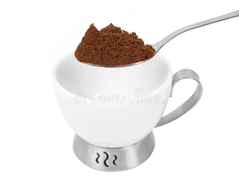 Spoon with ground coffee over white cup