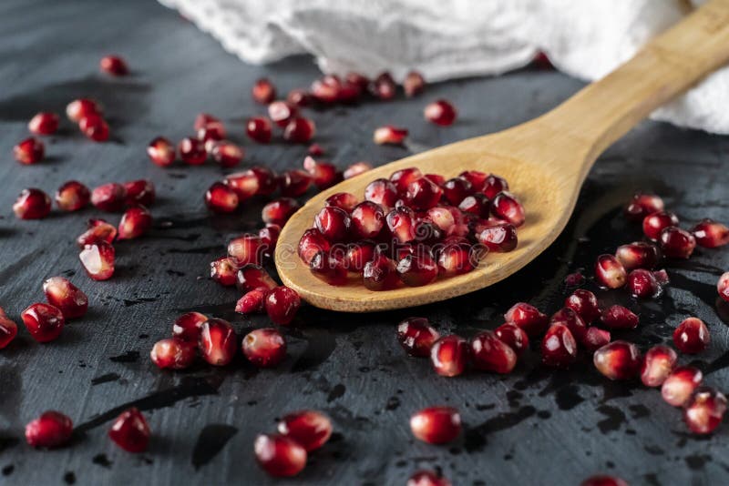 a spoon with pomegranate fruit flat lay with seed and grains on the table flat lays