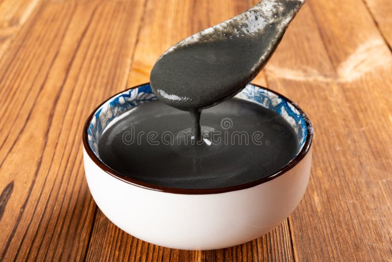 A spoon taking out black sesame paste