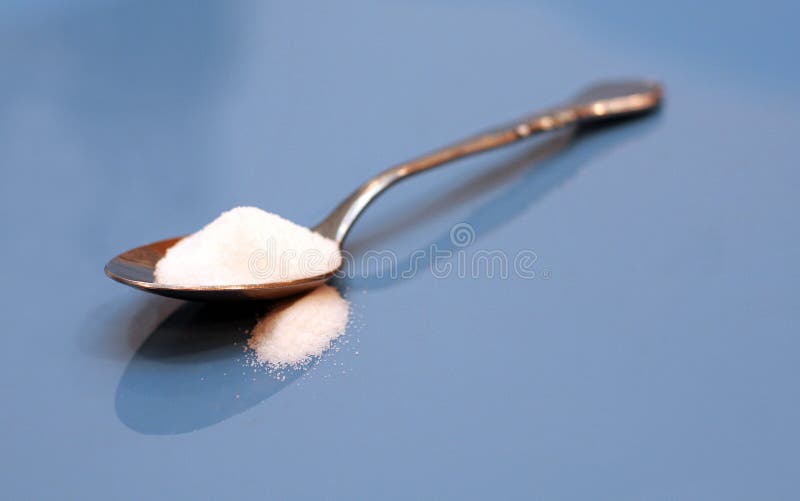 Spoonful of sugar on blue background