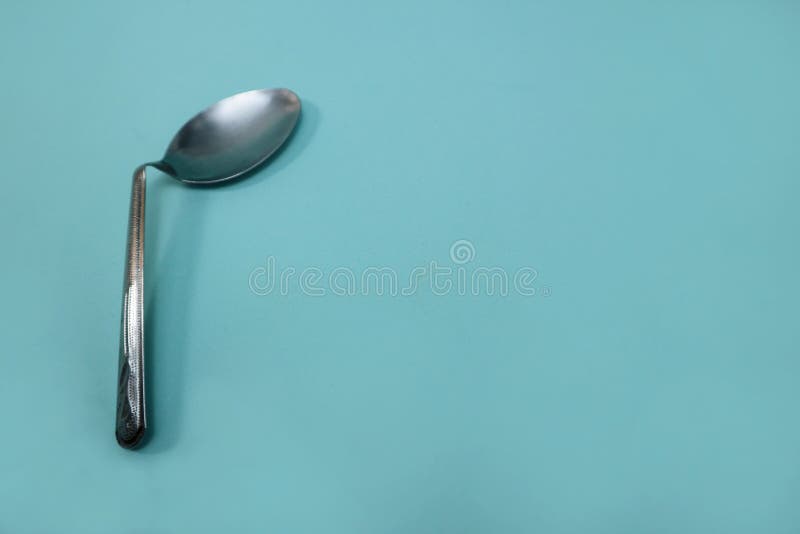 A Used and Bent Spoon, Isolated on a Blue Background. Stock Image Image of close, hand 254536633