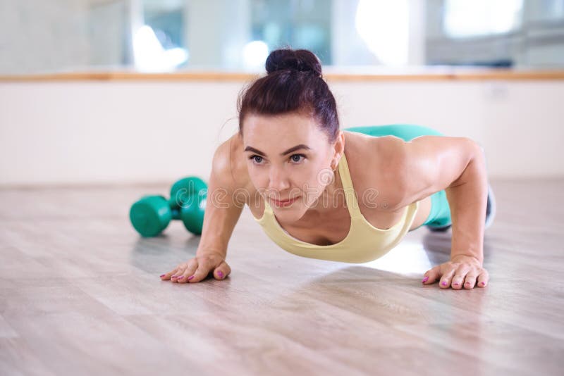 Sport. Beautiful athletic girl doing push-ups exercises in the gym stock photo Sport. Beautiful athletic girl doing push-ups exercises in the gym stock photo