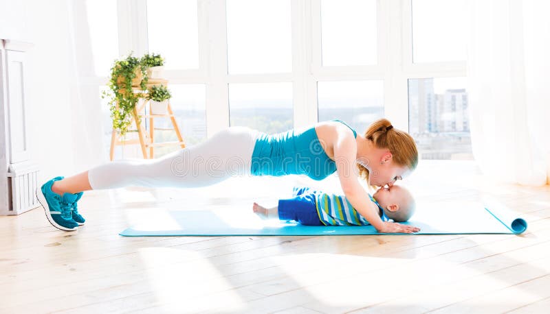 Sports mother is engaged in fitness and yoga with a baby at home. Sports mother is engaged in fitness and yoga with a baby at home