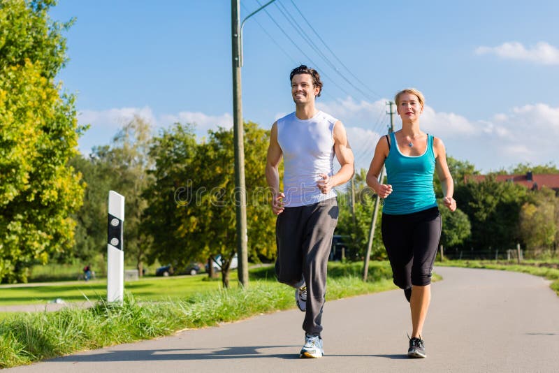 Sport couple running and jogging on rural street