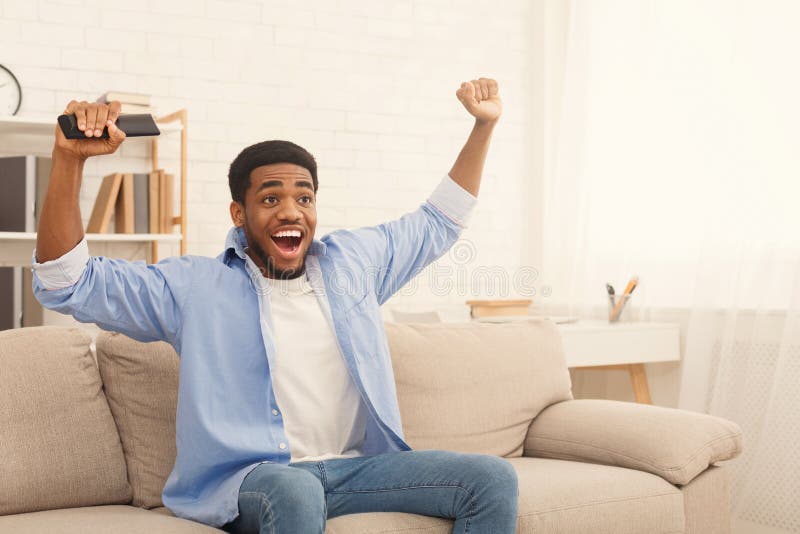 Sport di sorveglianza emozionanti del tipo nero sulla TV a casa immagine stock Sport di sorveglianza emozionanti del tipo nero sulla TV a casa immagine stock