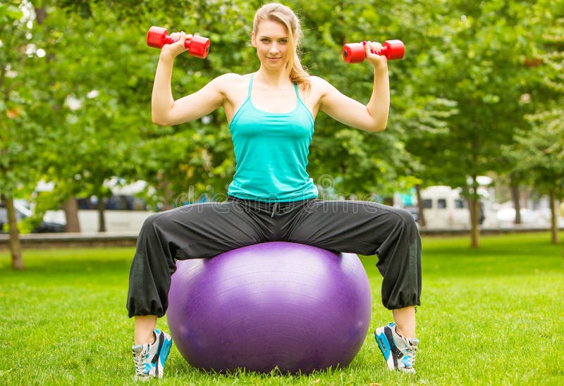 Sport dziewczyny ćwiczenie z dumbbells w parku obraz stock Sport dziewczyny ćwiczenie z dumbbells w parku obraz stock