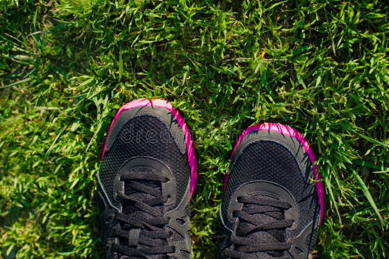 Sport Footwear on Female Feet on Green Grass. Closeup Running Shoes. royalty free stock photography Sport Footwear on Female Feet on Green Grass. Closeup Running Shoes. royalty free stock photography
