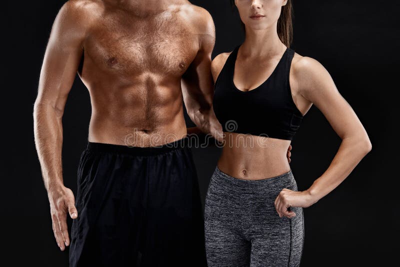 Sport, forme physique, concept de séance d'entraînement Couples convenables, homme musculaire fort et femme mince posant sur un f image stock Sport, forme physique, concept de séance d'entraînement Couples convenables, homme musculaire fort et femme mince posant sur un f image stock