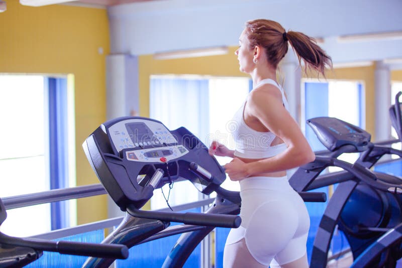 Sport, forme physique, mode de vie, technologie et concept de personnes - jeune femme courant sur le tapis roulant photo stock Sport, forme physique, mode de vie, technologie et concept de personnes - jeune femme courant sur le tapis roulant photo stock