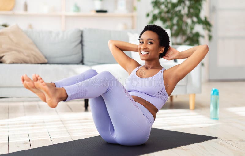 Sport podczas kwarantanny. atrakcyjna czarna kobieta uprawiająca fitness na matie sportowej w domu, ćwicząca mięśnie brzucha