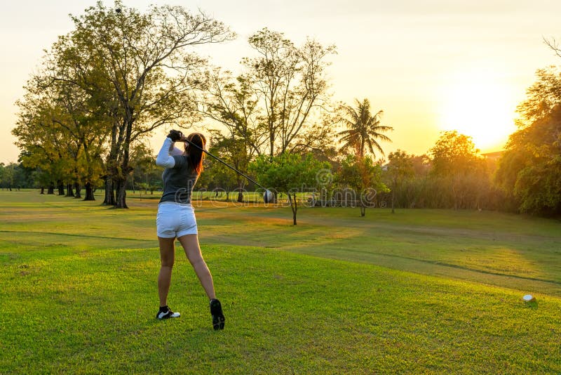 Sport sain Joueur sportif asiatique de golfeur de femme faisant la pi?ce en t d'oscillation de golf le temps ?galisant vert, elle image stock Sport sain Joueur sportif asiatique de golfeur de femme faisant la pi?ce en t d'oscillation de golf le temps ?galisant vert, elle image stock