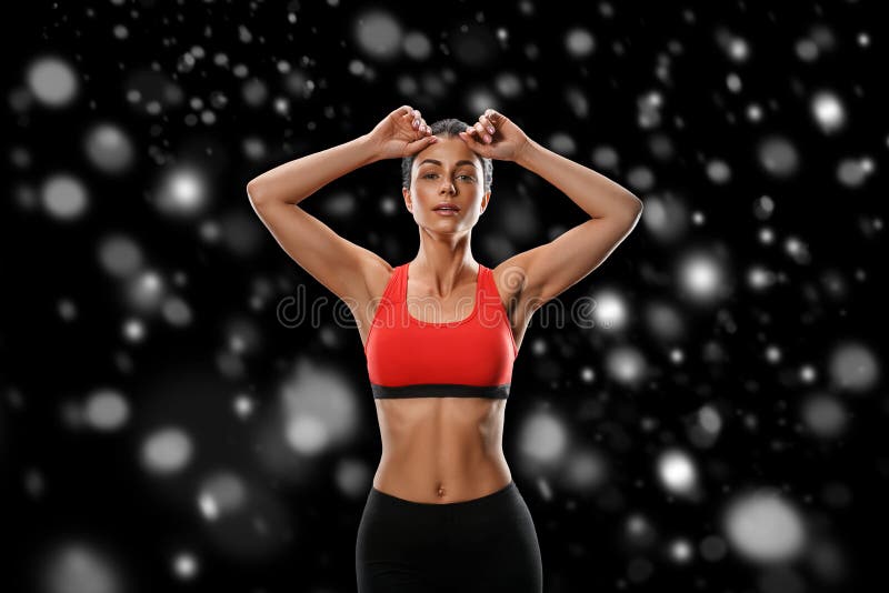 Sport. Woman sport body strong and beautiful Winter concept with snow snowflakes. Studio shot.