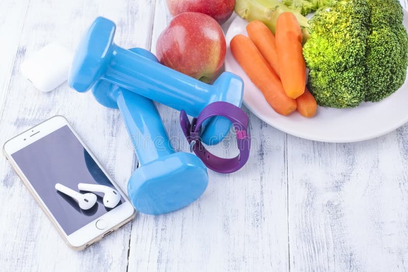 Sportausrüstung, blaue Dummköpfe und Früchte, Gemüse und Telefon Eignungsarmband und -kopfhörer für Musik Freier Raum für stockfotografie Sportausrüstung, blaue Dummköpfe und Früchte, Gemüse und Telefon Eignungsarmband und -kopfhörer für Musik Freier Raum für stockfotografie