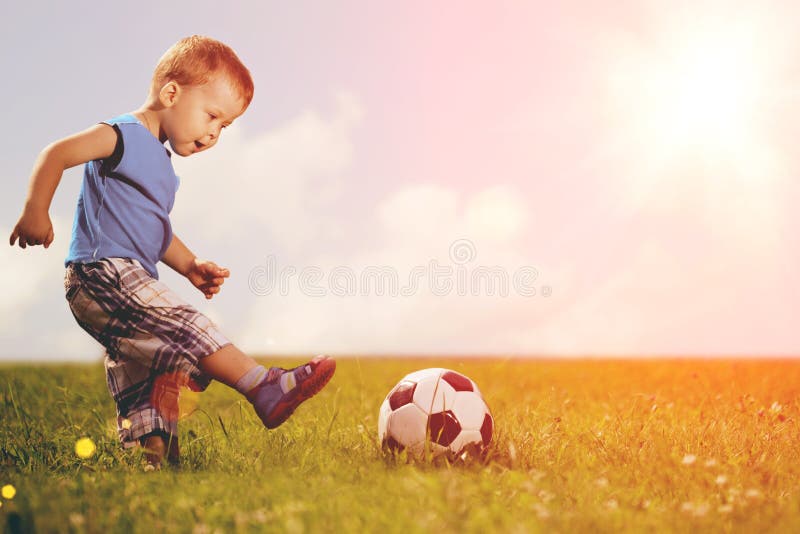 Sportenjong geitje De SpeelVoetbal van de jongen Baby met Bal op Sportterrein royalty-vrije stock fotografie Sportenjong geitje De SpeelVoetbal van de jongen Baby met Bal op Sportterrein royalty-vrije stock fotografie