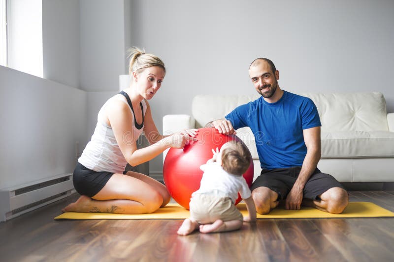 Sportfamilie nimmt an Eignung und Yoga mit einem Baby zu Hause teil