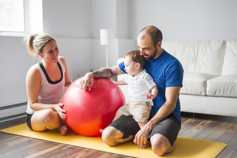 Sportfamilie nimmt an Eignung und Yoga mit einem Baby zu Hause teil