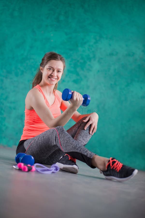 Sportfitness meisje met domoren - op de turkooise achtergrond De snoepjes zijn Ongezond Ongezonde kost Op dieet zijnd, Gezonde Ea royalty-vrije stock afbeelding Sportfitness meisje met domoren - op de turkooise achtergrond De snoepjes zijn Ongezond Ongezonde kost Op dieet zijnd, Gezonde Ea royalty-vrije stock afbeelding