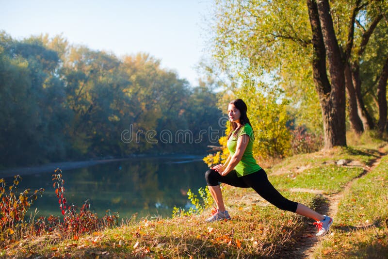 Sportfrau, die heraus beim Laufen in den Wald ausdehnt stockfotos Sportfrau, die heraus beim Laufen in den Wald ausdehnt stockfotos