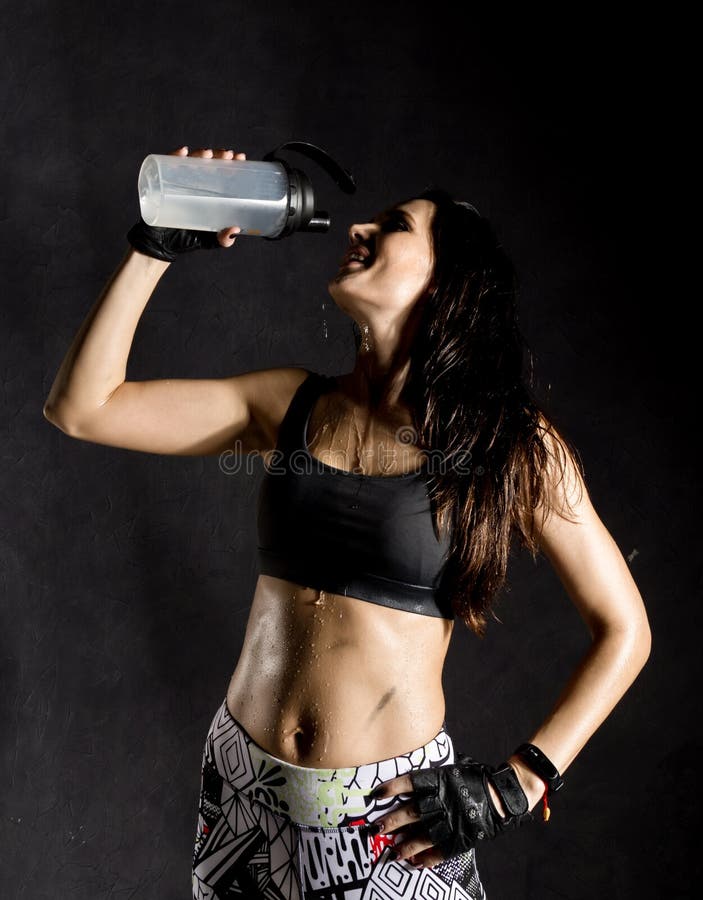 Sportief vrouwelijk bokser of mmavechters drinkend en bespattend water in haar gezicht mooie vrouwelijke geschiktheidsvrouw op zw royalty-vrije stock foto Sportief vrouwelijk bokser of mmavechters drinkend en bespattend water in haar gezicht mooie vrouwelijke geschiktheidsvrouw op zw royalty-vrije stock foto
