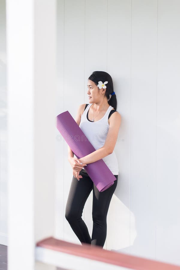Sportieve Aziatische vrouwelijke handen die yogamat na een training, een Oefeningsmateriaal, een Gezond fitness en een sportconce stock foto's Sportieve Aziatische vrouwelijke handen die yogamat na een training, een Oefeningsmateriaal, een Gezond fitness en een sportconce stock foto's