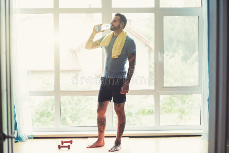 Sportieve mens die, hebbend onderbrekings drinkwater rusten royalty-vrije stock afbeeldingen Sportieve mens die, hebbend onderbrekings drinkwater rusten royalty-vrije stock afbeeldingen
