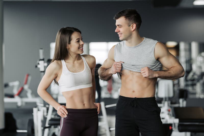 Sportig konditionparvisning i idrottshall H?rlig idrotts- man och kvinna, muskul?s torsoabs arkivfoto Sportig konditionparvisning i idrottshall H?rlig idrotts- man och kvinna, muskul?s torsoabs arkivfoto