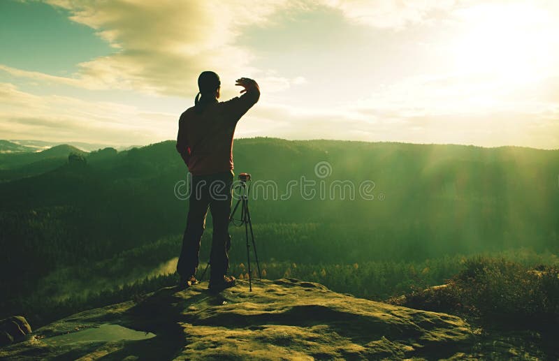Sportig man på bergmaximumet som ser på bergdalen arkivfoto Sportig man på bergmaximumet som ser på bergdalen arkivfoto