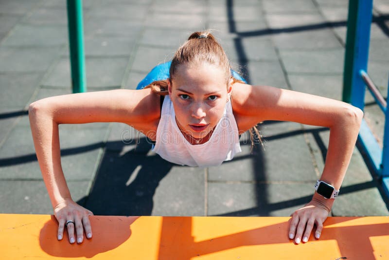 Sportig ung sexig kvinna som gör skjuta-UPS från bänk på sportfält Sund livsstil för begrepp fotografering för bildbyråer Sportig ung sexig kvinna som gör skjuta-UPS från bänk på sportfält Sund livsstil för begrepp fotografering för bildbyråer