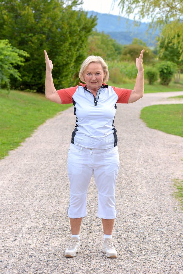 Sportig äldre kvinna som gör sportövningar arkivfoto Sportig äldre kvinna som gör sportövningar arkivfoto