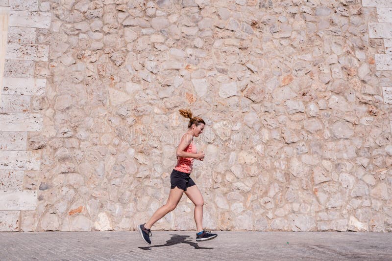 Sportlerin mittleren Alters mit Fitness-Kleidung, die in der Sonne trainieren und im Sommer schwitzend in der Sonne laufen und im lizenzfreie stockfotos Sportlerin mittleren Alters mit Fitness-Kleidung, die in der Sonne trainieren und im Sommer schwitzend in der Sonne laufen und im lizenzfreie stockfotos