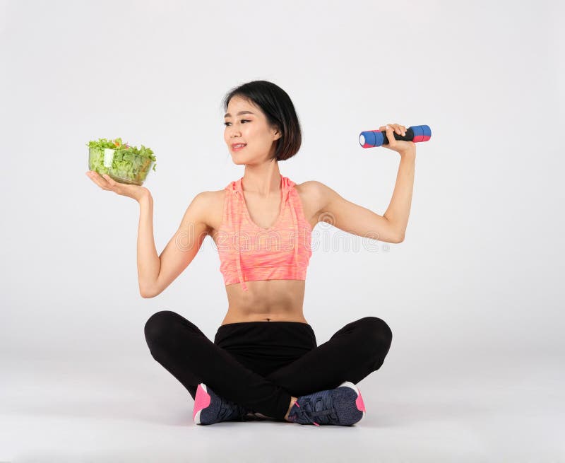 Sportliche Fitness-Frau in Sportbekleidung mit Gemüsesalat-Dumbell auf weißem Grund gesunder Sport stockfoto Sportliche Fitness-Frau in Sportbekleidung mit Gemüsesalat-Dumbell auf weißem Grund gesunder Sport stockfoto