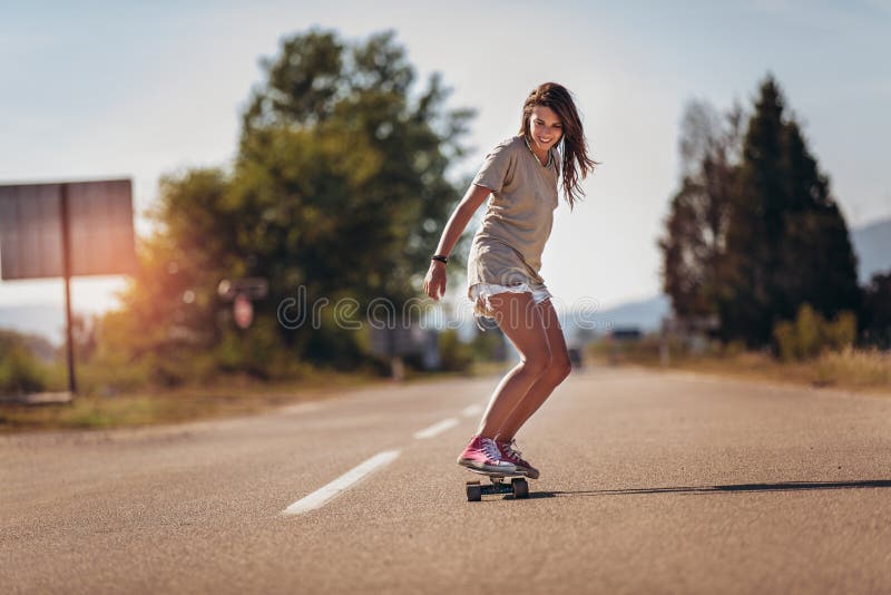 Sportliche Frau, die auf dem Skateboard auf der Straße reitet