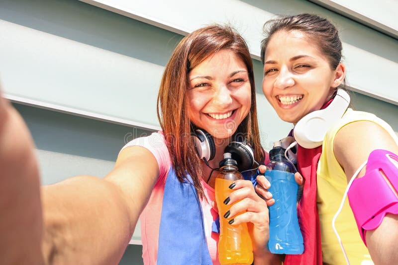 Sportliche Freundinnen, die selfie während eines Bruches an Lauftraining nehmen stockbild Sportliche Freundinnen, die selfie während eines Bruches an Lauftraining nehmen stockbild