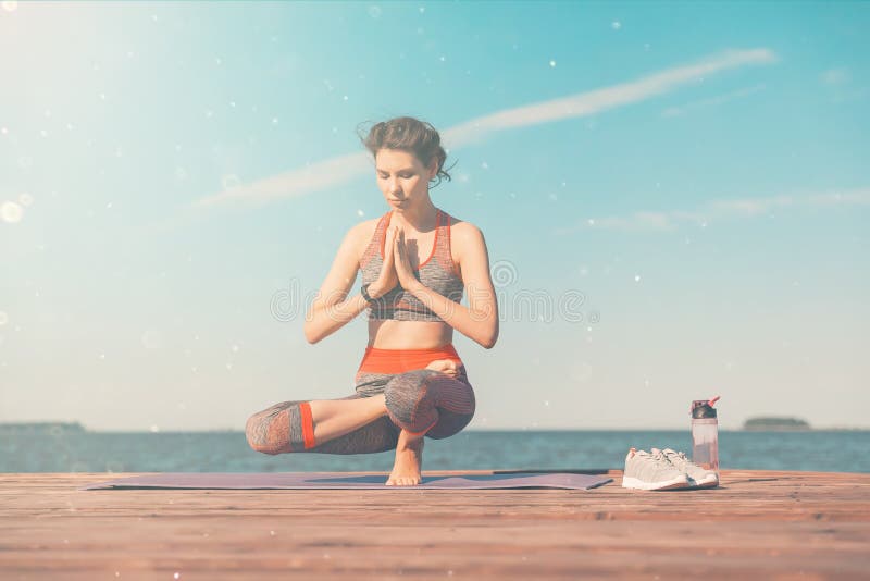 Sportliches junges M?dchen morgens auf dem Pier auf K?ste, ?bendes Yoga Frau tun Gymnastik drau?en Gesundheit und Yoga stockfotografie Sportliches junges M?dchen morgens auf dem Pier auf K?ste, ?bendes Yoga Frau tun Gymnastik drau?en Gesundheit und Yoga stockfotografie