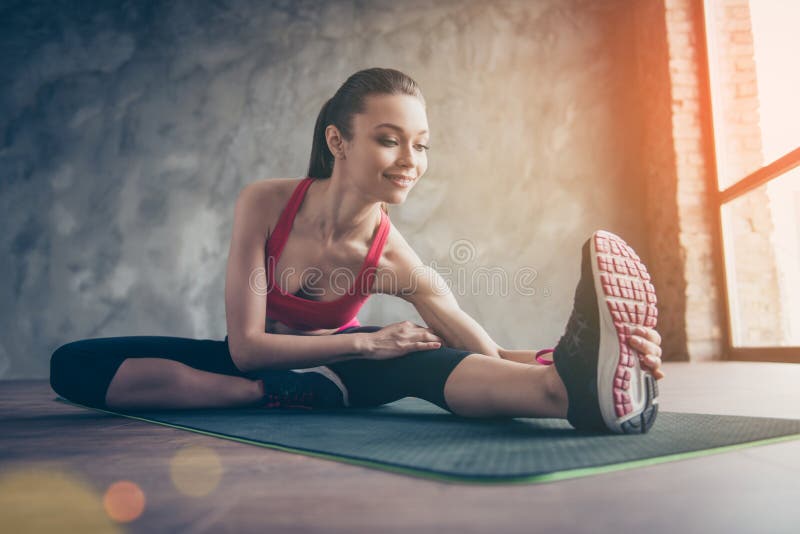 Sportliches sportliches Mädchen der Junge recht, das auf einen Teppich nach Kundenberaterin ausdehnt stockfotos Sportliches sportliches Mädchen der Junge recht, das auf einen Teppich nach Kundenberaterin ausdehnt stockfotos