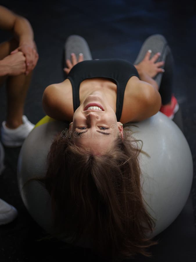 Sportowa kobieta w sporty odziewa robić ćwiczeniom na sprawności fizycznej piłce na gym tle Dieta, zdrowy pojęcie obraz royalty free
