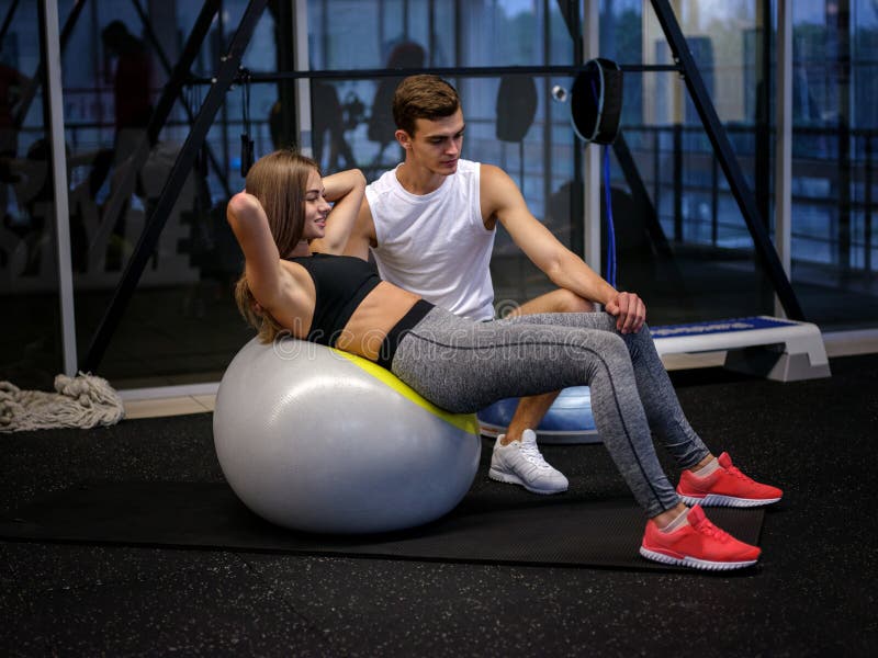 Sportowa kobieta w sporty odziewa robić ćwiczeniom na sprawności fizycznej piłce na gym tle Dieta, zdrowy pojęcie zdjęcia royalty free