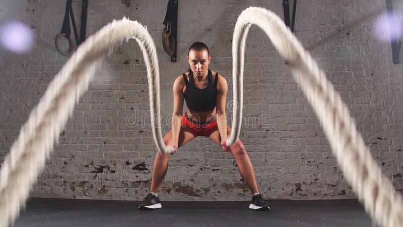 Sportowa młoda kobieta robi niektóre crossfit ćwiczy z arkaną salową swobodny ruch