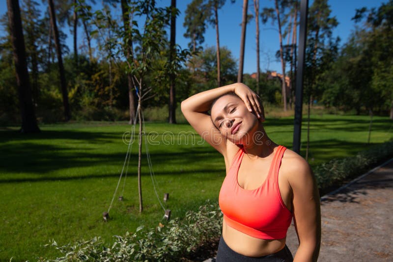 Sportowiec w sztuce sportowej ma na szyi pomóż sobie ręką i uśmiechając się. sporty na wolnym powietrzu obrazy stock