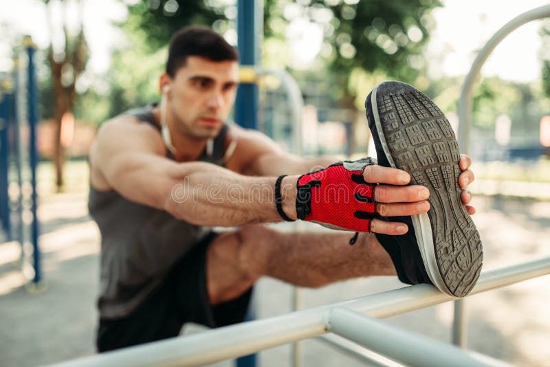 Sportowy mężczyzna robi rozciągania ćwiczeniu plenerowemu obrazy stock Sportowy mężczyzna robi rozciągania ćwiczeniu plenerowemu obrazy stock