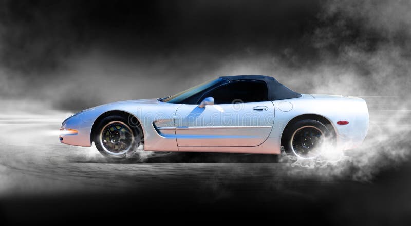 A silver corvette sports car accelerating with smoke coming from wheels.