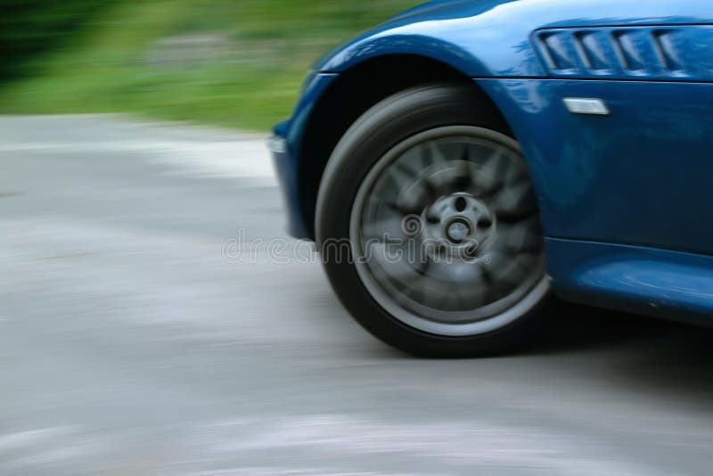 Filatura ruota anteriore di una vettura sportiva, mentre l'assunzione di una rapida svolta a sinistra su una strada tortuosa.