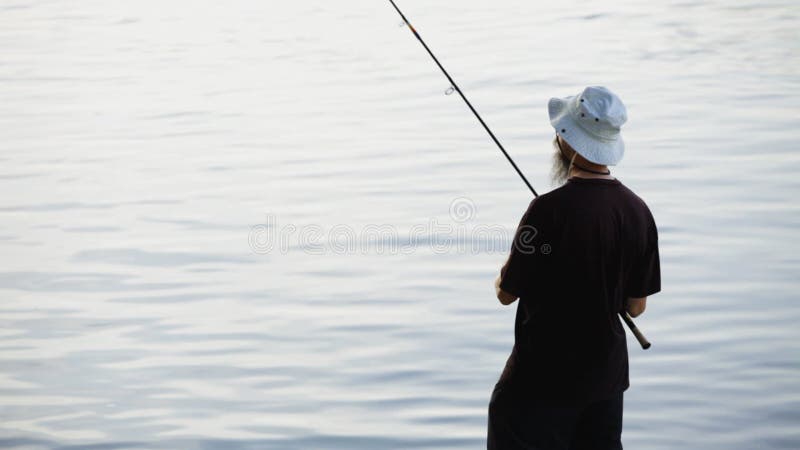 Sports fisherman fishing on river, using fishing lures