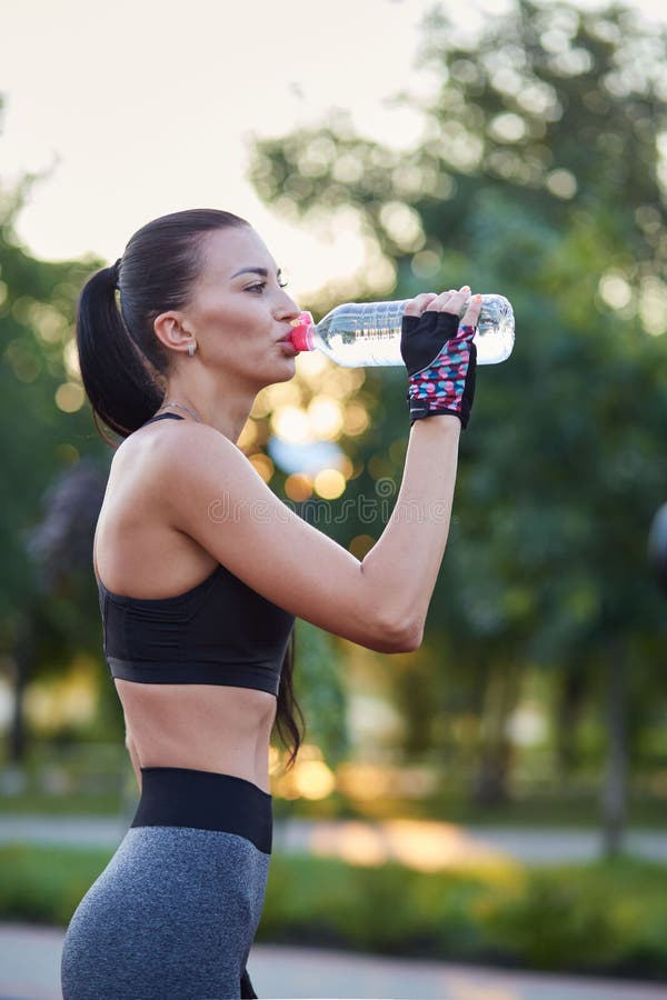 Sports Girl Drinking Water from a Plastic Bottle after Training Stock