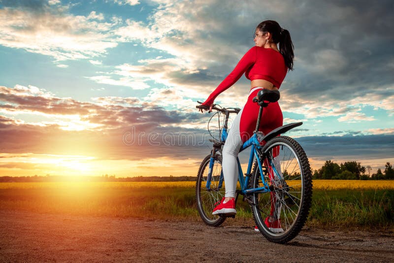 Sports Training on a Bicycle. Beautiful Girl in a Sports Suit on a Sunset  Background Stock Image - Image of cycle, biking: 190253359