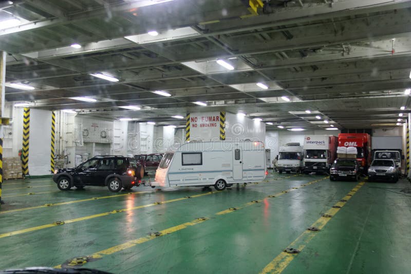 Car towing a caravan maneuvering on the deck of a car ferry