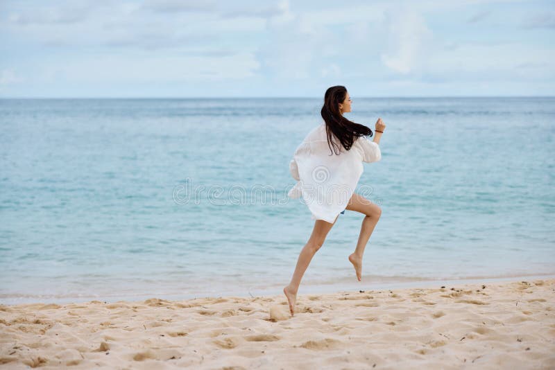 Sports Woman Runs Along the Beach in Summer Clothes on the Sand in a ...